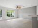 A spacious living room with tile flooring and access to the screened in porch at 567 Mount Olympus Blvd, New Smyrna Beach, FL 32168