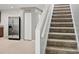 View of carpeted stairs adjacent to a stainless steel refrigerator in this cozy home at 567 Mount Olympus Blvd, New Smyrna Beach, FL 32168