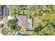 Aerial view of a house with screened in pool, lush landscaping, and mature trees on a sunny day at 6088 Sabal Hammock Cir, Port Orange, FL 32128