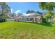 The backyard boasts a screened lanai, green grass, and well-placed patio furniture for relaxation at 6088 Sabal Hammock Cir, Port Orange, FL 32128