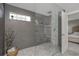 Contemporary bathroom features a glass-enclosed shower, neutral tones, and convenient access to the main bedroom at 6088 Sabal Hammock Cir, Port Orange, FL 32128