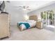Serene main bedroom features a ceiling fan, a plush bed, and direct access to a private outdoor space at 6088 Sabal Hammock Cir, Port Orange, FL 32128