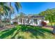 Attractive single-story home with arched windows, a well-kept lawn, and mature landscaping at 6088 Sabal Hammock Cir, Port Orange, FL 32128