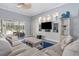 Comfortable living room featuring neutral tones, built-in shelving, and a view of the screened lanai at 6088 Sabal Hammock Cir, Port Orange, FL 32128