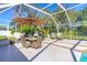 Inviting screened-in patio with dining set, lounge chairs, and umbrella for outdoor entertaining and relaxation at 6088 Sabal Hammock Cir, Port Orange, FL 32128