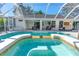 Screened in pool and spa surrounded by white tile patio at 6088 Sabal Hammock Cir, Port Orange, FL 32128