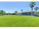 Expansive backyard features a well-manicured lawn, landscaping, and a pond view at 637 Marisol Dr, New Smyrna Beach, FL 32168