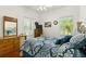 Comfortable bedroom with a dresser, mirror, ceiling fan, and two large windows at 637 Marisol Dr, New Smyrna Beach, FL 32168