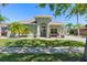 Charming single-story home with lush landscaping, a well-manicured lawn and beautiful tropical palm trees at 637 Marisol Dr, New Smyrna Beach, FL 32168