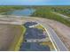 Aerial view of the community showing rooflines, a pond, and the surrounding area at 6456 Roseberry Ct, Port Orange, FL 32128