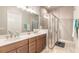 Stylish bathroom featuring double sinks, quartz countertops, modern fixtures, and a walk-in glass shower at 6456 Roseberry Ct, Port Orange, FL 32128