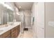 Modern bathroom featuring double sinks, white quartz countertops, and a glass-enclosed shower at 6456 Roseberry Ct, Port Orange, FL 32128