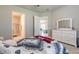 Comfortable bedroom with grey walls, soft carpet, and an open doorway to an adjacent room at 6456 Roseberry Ct, Port Orange, FL 32128
