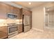 Modern kitchen with stainless steel appliances, wooden cabinetry, and an open layout for easy movement at 6456 Roseberry Ct, Port Orange, FL 32128
