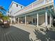 Spacious porch beneath a home, with stairs to the upper deck and seating at 6530 S Atlantic Ave, New Smyrna Beach, FL 32169