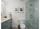 Bright bathroom featuring a glass enclosed shower, sleek toilet, and framed art pieces on the wall at 6530 S Atlantic Ave, New Smyrna Beach, FL 32169
