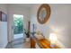 Stylish entryway with wooden console table, decorative mirror, and bright light from the door at 6530 S Atlantic Ave, New Smyrna Beach, FL 32169