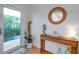 Bright entryway features a wood console table with decorative accents and a round mirror at 6530 S Atlantic Ave, New Smyrna Beach, FL 32169