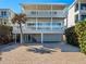 Coastal home featuring balconies, a paver driveway, and a convenient under-house garage for parking at 6530 S Atlantic Ave, New Smyrna Beach, FL 32169