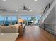 Bright living room showcasing ocean views, hardwood floors, stairs, and comfortable furniture at 6530 S Atlantic Ave, New Smyrna Beach, FL 32169