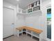 Organized mudroom with built-in bench, storage shelves, and tiled floor near the doorway at 6530 S Atlantic Ave, New Smyrna Beach, FL 32169
