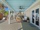 Inviting covered patio featuring comfortable seating, ceiling fans, and access to stairs at 6530 S Atlantic Ave, New Smyrna Beach, FL 32169