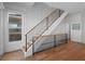 An interior view of a modern staircase with wood treads, a black metal railing, and large windows at 6530 S Atlantic Ave, New Smyrna Beach, FL 32169