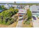 Aerial view of a cozy blue home with a red trim, surrounded by lush trees and neighboring houses near the Intracoastal Waterway at 6860 Turtlemound Rd, New Smyrna Beach, FL 32169