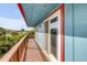 Charming balcony with wooden railing and blue siding, perfect for enjoying the views at 6860 Turtlemound Rd, New Smyrna Beach, FL 32169