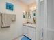 Bright bathroom with white vanity, ample lighting, and linen closet provides functionality at 6860 Turtlemound Rd, New Smyrna Beach, FL 32169