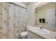 Bathroom with patterned shower curtain, neutral walls, a white toilet, and a sink with cabinetry at 6860 Turtlemound Rd, New Smyrna Beach, FL 32169