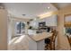 Well-lit kitchen with white cabinetry, modern appliances, and a breakfast bar, open to the adjacent dining area at 6860 Turtlemound Rd, New Smyrna Beach, FL 32169