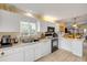 Well-lit kitchen features tiled floors, white cabinets, modern appliances, and breakfast bar at 6860 Turtlemound Rd, New Smyrna Beach, FL 32169