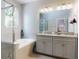 Bright bathroom featuring a soaking tub, walk-in shower, dual vanity with granite counters at 727 Porter Rye Ave, Debary, FL 32713