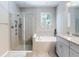 Bright bathroom featuring a walk-in shower, soaking tub, vanity with granite counters, and window at 727 Porter Rye Ave, Debary, FL 32713