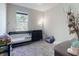 Neutral-toned Bedroom features a crib, dresser, and large sunlit window at 727 Porter Rye Ave, Debary, FL 32713