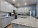 Spacious kitchen features a granite-topped island, stainless steel appliances, and sleek gray cabinetry at 727 Porter Rye Ave, Debary, FL 32713