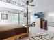 Bright main bedroom with canopy bed, ceiling fan, windows, and view to ensuite bathroom at 727 Porter Rye Ave, Debary, FL 32713