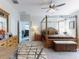 Spacious main bedroom with a four-poster bed, ceiling fan, and ensuite bathroom access at 727 Porter Rye Ave, Debary, FL 32713