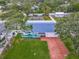 Aerial shot of a well-maintained home with a brick driveway and a landscaped backyard with screen enclosed pool at 805 E 15Th Ave, New Smyrna Beach, FL 32169