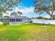 Large backyard featuring well-maintained lawn, mature trees, landscaping, and screened in pool area at 805 E 15Th Ave, New Smyrna Beach, FL 32169