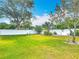 Spacious backyard with green grass, mature trees, landscaping, and a privacy fence at 805 E 15Th Ave, New Smyrna Beach, FL 32169