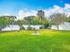 Manicured backyard with a privacy fence, green lawn, mature landscaping, and a bird bath at 805 E 15Th Ave, New Smyrna Beach, FL 32169