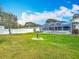 Well-kept backyard features a privacy fence, lush green grass, landscaping, and screened pool enclosure at 805 E 15Th Ave, New Smyrna Beach, FL 32169