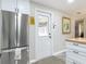Bright kitchen area features stainless steel refrigerator and a door leading to the garage at 805 E 15Th Ave, New Smyrna Beach, FL 32169