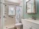 Compact bathroom features a shower with accessibility bar, white tile, and a vanity with integrated sink at 830 Christy Dr, Port Orange, FL 32129
