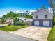 Exterior of home and a spacious building in the rear, showcasing a long, paved driveway at 830 Christy Dr, Port Orange, FL 32129