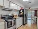 Bright kitchen featuring stainless steel appliances, tiled countertops and access to the dining area at 830 Christy Dr, Port Orange, FL 32129