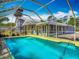 A backyard pool with surrounding lanai and a distant view of the house presents an inviting recreational space at 830 Christy Dr, Port Orange, FL 32129