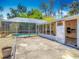View of a backyard pool with a screened enclosure and a sunroom with a concrete patio at 830 Christy Dr, Port Orange, FL 32129